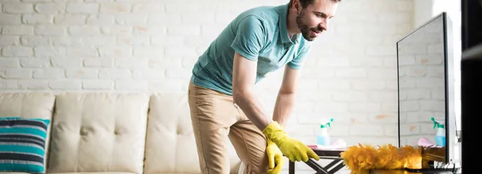 Man dusting his house with a duster