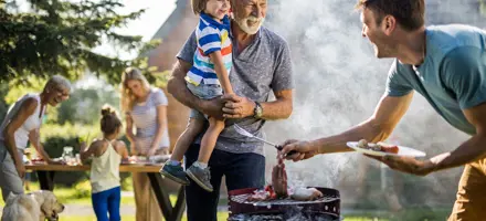 Man bereidt een barbecue voor in de achtertuin van het gezin