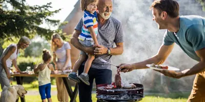 Ein Mann bereitet einen Grill im Garten vor
