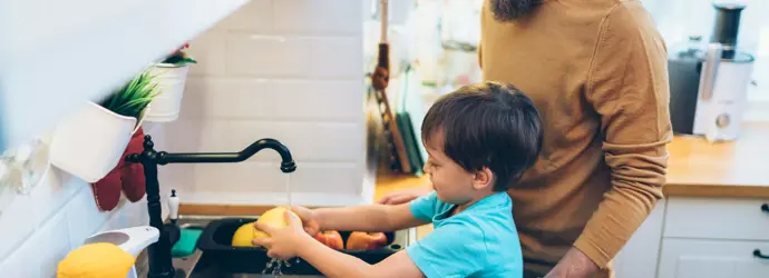 Eine Mutter hilft ihren Kindern sich die Hände zu waschen