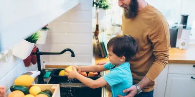 Eine Mutter hilft ihren Kindern sich die Hände zu waschen