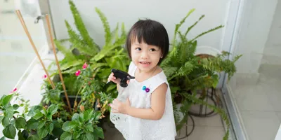 Little girl taking care of indoor plants