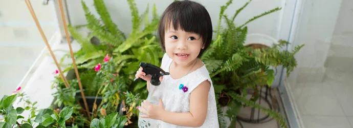 Little girl taking care of indoor plants