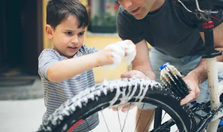 Father and son cleaning a bicycle