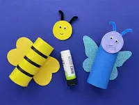 A paper tube butterfly is to the right, with a glue stick in the middle and the tube and face of the bee ready to stick.