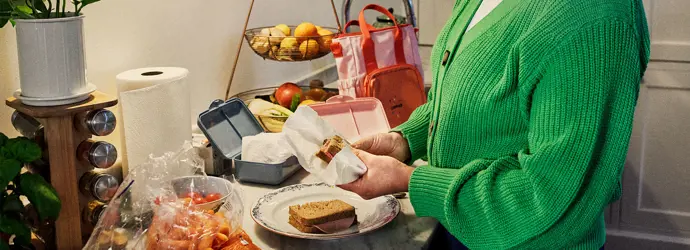 Woman preparing sandwiches in the kitchen for a school lunchbox.