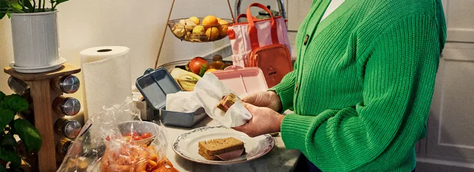 Woman preparing sandwiches in the kitchen for a school lunchbox.