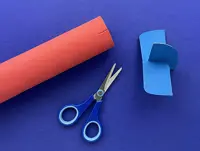 The paper towel tube with two notches cut at the back and the rear wing and tail of the plane, fitted together in an ‘X’ shape.