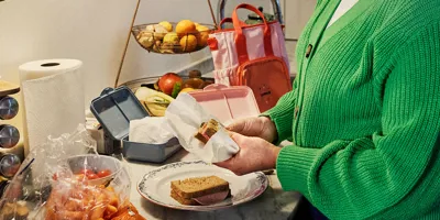 Eine Frau bereitet in der Küche Sandwiches für eine Schulbrotdose vor.
